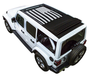 White JL four door Power Top Jeep with Solid Tactical American Flag black SPIDERWEBSHADE shade on top that covers front and rear passenger seats.