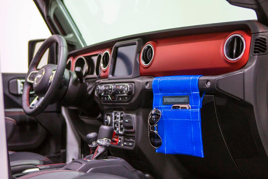 A blue GrabBag JL attached to the interior door of a Jeep Wrangler JL.