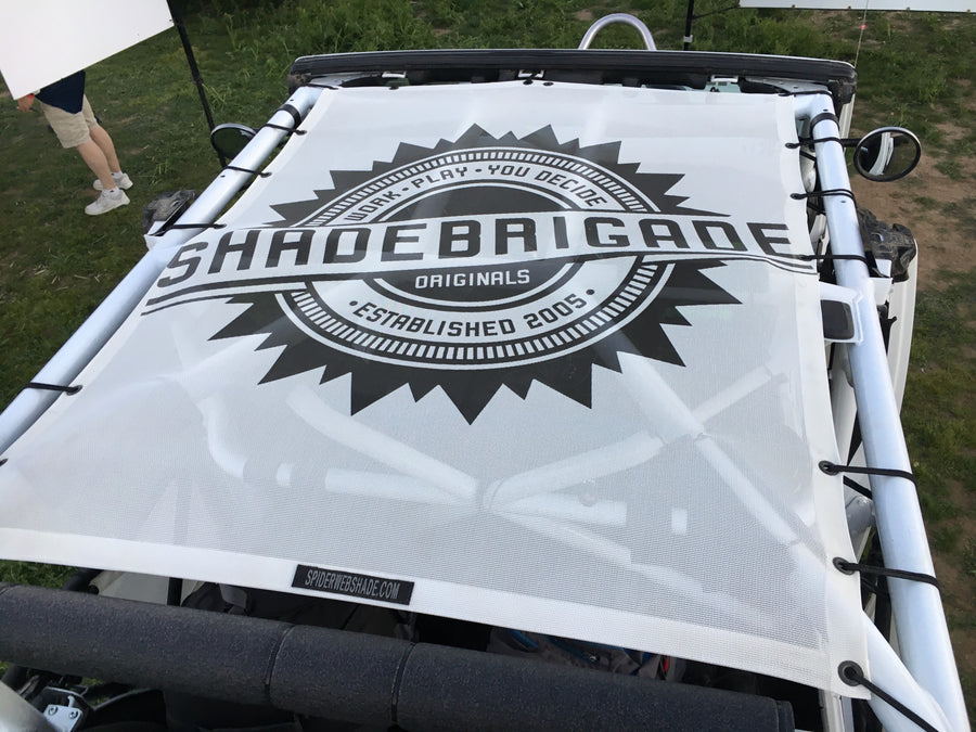 White custom printed shadetop with the shadebrigade logo in black on the top of a Jeep. 