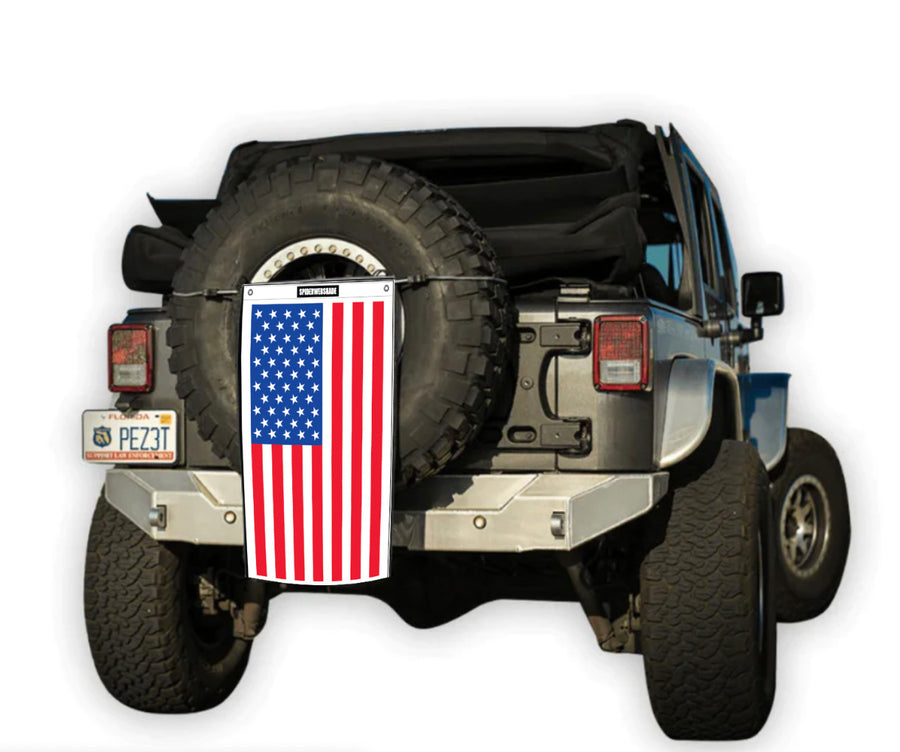 Jeep with Trailsac on rear tire with an American Flag design on it being held up with a trailcord around tire.