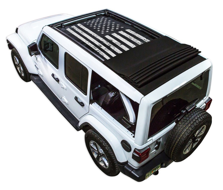 White JL four door Power Top Jeep with Distressed Tactical American Flag black SPIDERWEBSHADE shade on top that covers front and rear passenger seats.