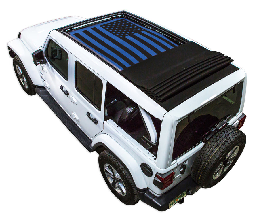 White JL four door Power Top Jeep with Solid Tactical American Flag blue SPIDERWEBSHADE shade on top that covers front and rear passenger seats.