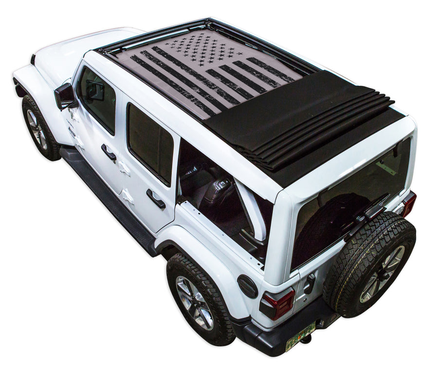 White JL four door Power Top Jeep with Distressed Tactical American Flag grey SPIDERWEBSHADE shade on top that covers front and rear passenger seats.