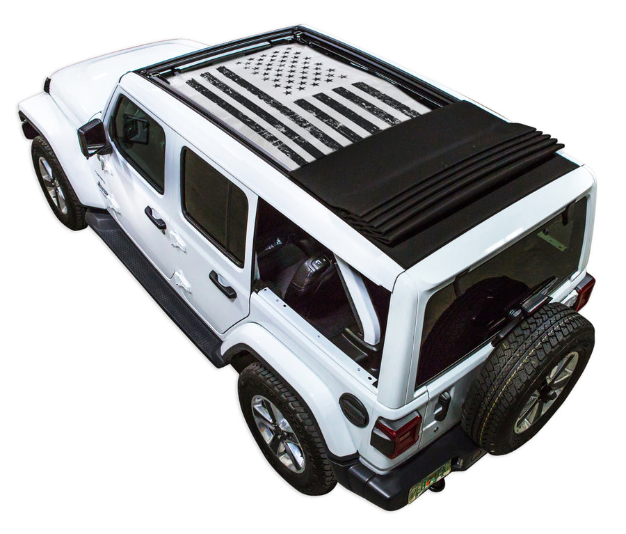 White JL four door Power Top Jeep with Distressed Tactical American Flag white SPIDERWEBSHADE shade on top that covers front and rear passenger seats.