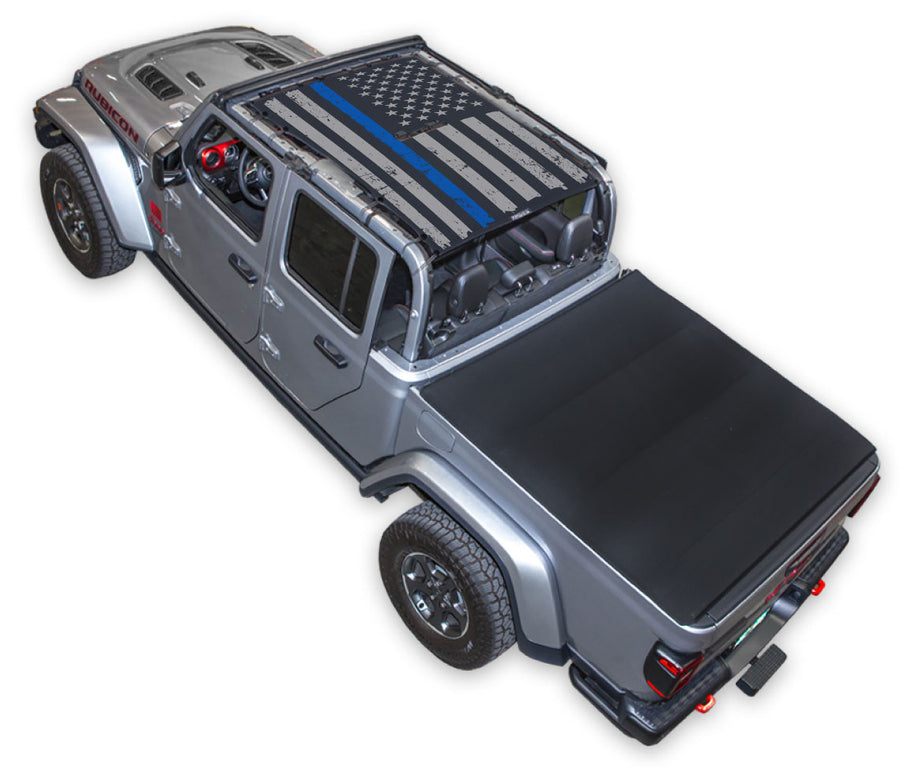 Silver Gladiator JT four door Jeep with Distressed Thin Blue Line tactical Flag Black SPIDERWEBSHADE shade on top that covers front and rear passenger seats.