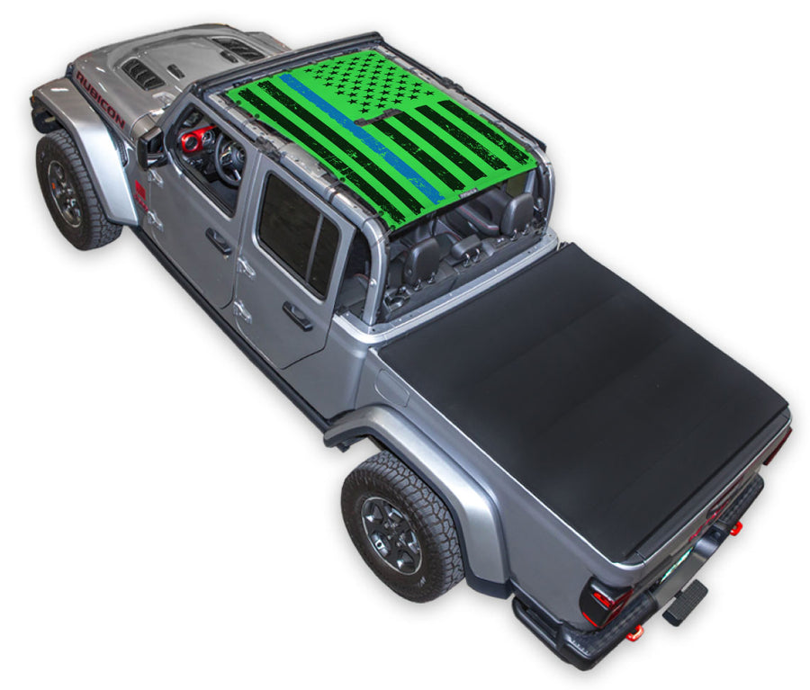Silver Gladiator JT four door Jeep with Distressed Thin Blue Line tactical Flag Green SPIDERWEBSHADE shade on top that covers front and rear passenger seats.