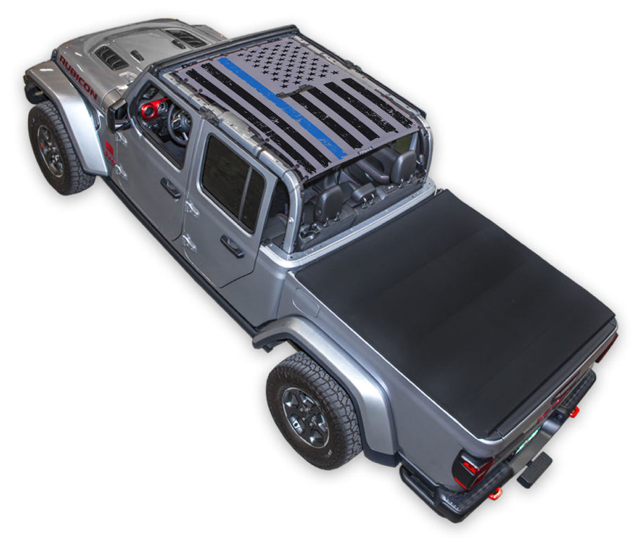 Silver Gladiator JT four door Jeep with Distressed Thin Blue Line tactical Flag grey SPIDERWEBSHADE shade on top that covers front and rear passenger seats.