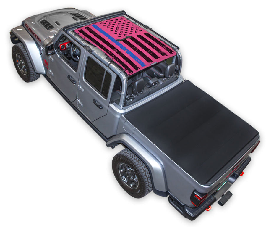 Silver Gladiator JT four door Jeep with Distressed Thin Blue Line tactical Flag pink SPIDERWEBSHADE shade on top that covers front and rear passenger seats.