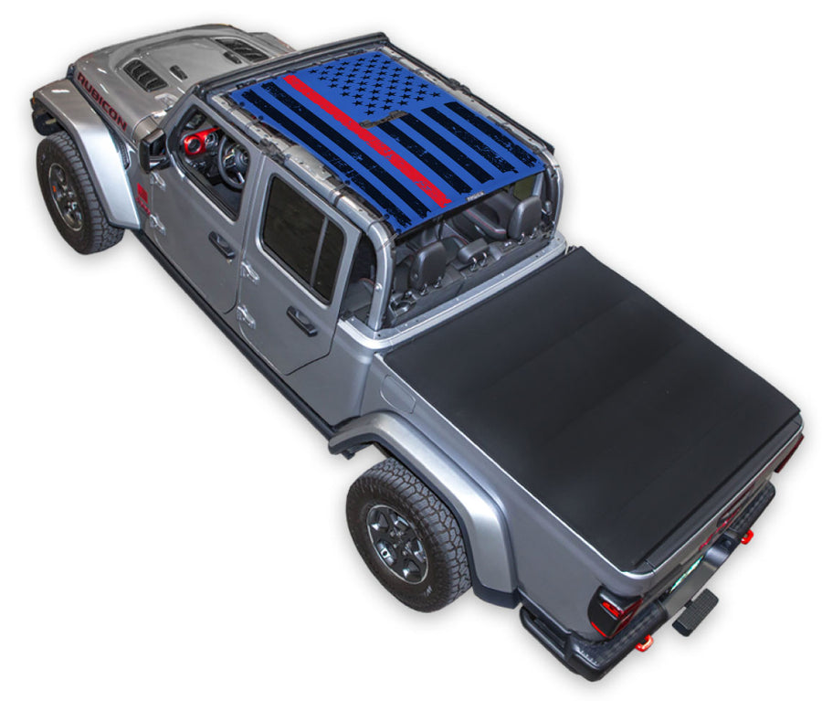 Silver Gladiator JT four door Jeep with Distressed Thin Red Line tactical Flag Blue SPIDERWEBSHADE shade on top that covers front and rear passenger seats.