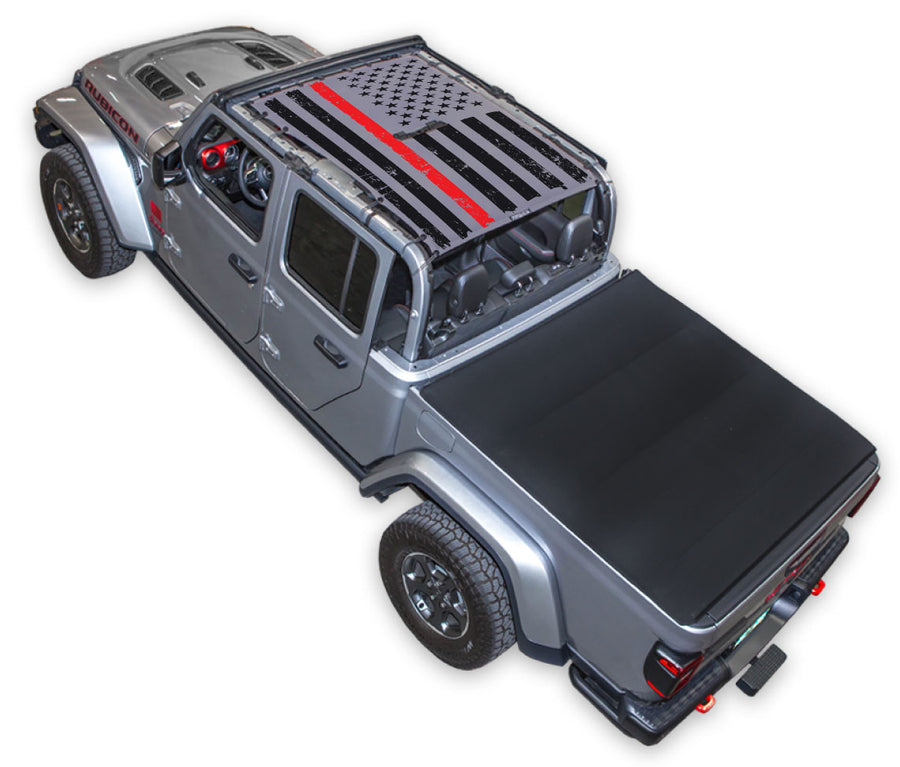 Silver Gladiator JT four door Jeep with Distressed Thin Red Line tactical Flag grey SPIDERWEBSHADE shade on top that covers front and rear passenger seats.