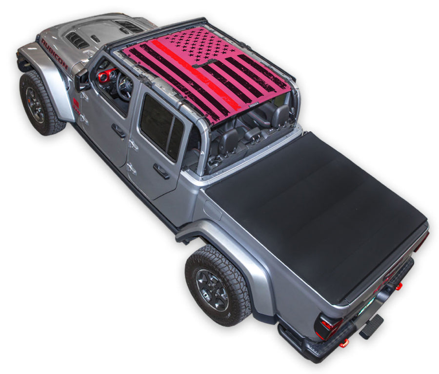 Silver Gladiator JT four door Jeep with Distressed Thin Red Line tactical Flag pink SPIDERWEBSHADE shade on top that covers front and rear passenger seats.