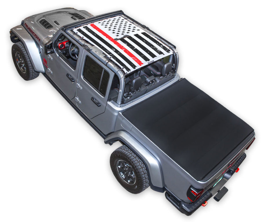 Silver Gladiator JT four door Jeep with Distressed Thin Red Line tactical Flag white SPIDERWEBSHADE shade on top that covers front and rear passenger seats.